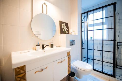 a bathroom with a sink and a toilet and a mirror at Complex Omnia - Apartamente Husi in Huşi