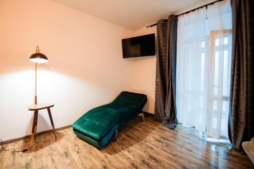 a green chair in a room with a large window at Complex Omnia - Apartamente Husi in Huşi