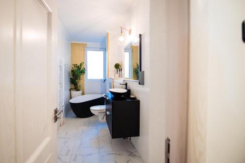 a bathroom with a sink and a toilet and a tub at Complex Omnia - Apartamente Husi in Huşi