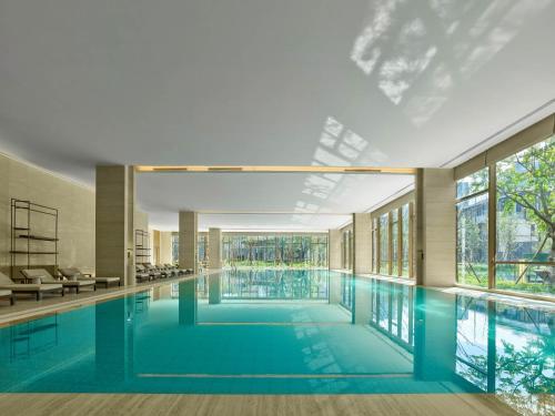 a large swimming pool in a building with windows at Banyan Tree Dongguan Songshan Lake in Dongguan