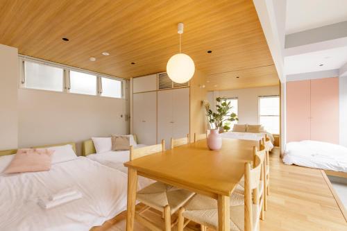 um quarto com uma mesa de jantar e 2 camas em Hotel Re:ONcE Shibuya em Tóquio