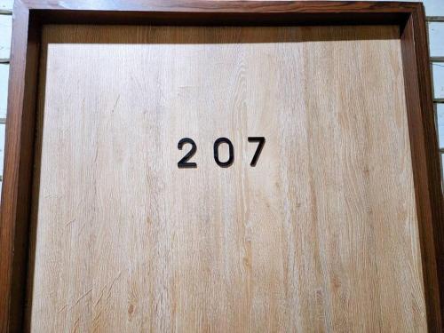 a wooden door with the number twentyseven on it at 207:Homely room in apartment Near BTS Kasetsart U. in Bangkok