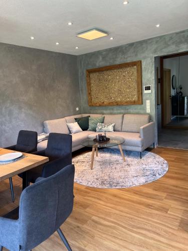 een woonkamer met een bank en een tafel en stoelen bij GreenView Appartement in Wiesing