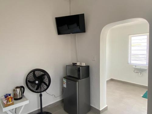 Habitación con ventilador y TV en la pared. en No1 Guest House, en Ciudad del Cabo