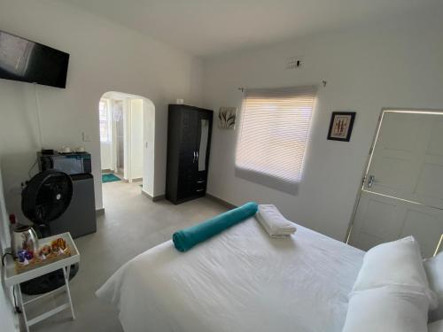 Un dormitorio con una gran cama blanca y una ventana en No1 Guest House, en Ciudad del Cabo