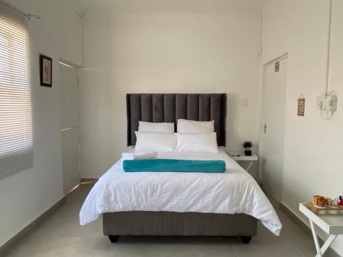 Un dormitorio con una cama grande con una almohada azul. en No1 Guest House, en Ciudad del Cabo