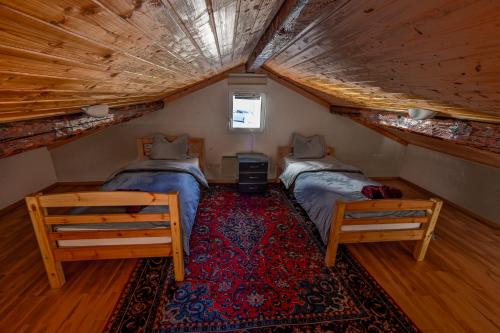 a attic bedroom with two beds and a rug at Douillet nid d'aigle in Daillon