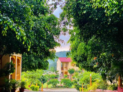 ein Haus inmitten eines Waldes voller Bäume in der Unterkunft Udai Nature Valley Resort by AN Hotels-A Peacefull river Retreat in Udaipur