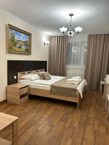 a bedroom with a large bed and a table at Skif Hotel in Astana