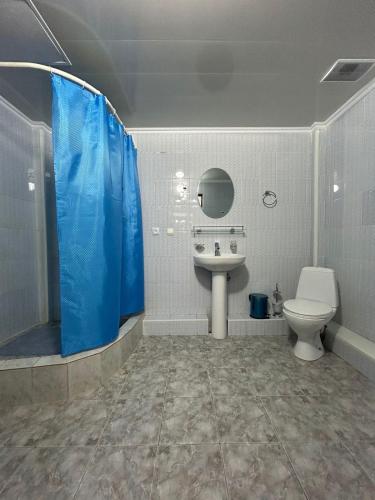 y baño con aseo, lavabo y ducha. en Skif Hotel, en Astana