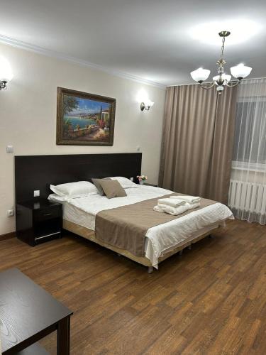 a bedroom with a large bed and a painting on the wall at Skif Hotel in Astana