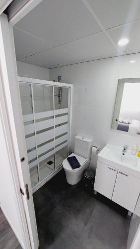 a white bathroom with a toilet and a sink at Lofts 4Towers - La Paz in Madrid