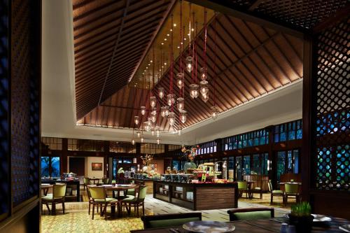 a restaurant with tables and chairs and a chandelier at eL Hotel Banyuwangi in Banyuwangi