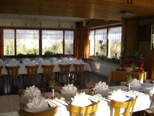 a room with tables and chairs with white tablecloths at Hotel Restaurant Bergheim in Flumserberg