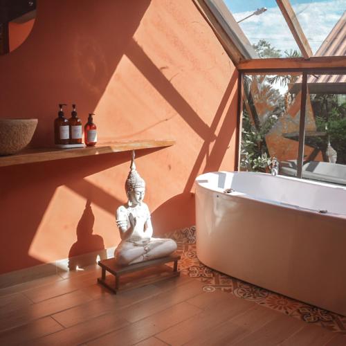 a bathroom with a bath tub and aitatingitating room with a bath tub at Umbral Hotel Boutique in Villavicencio