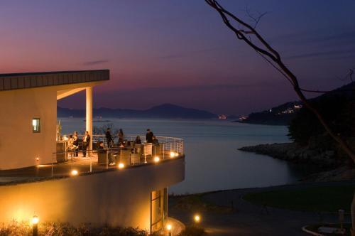 people sitting on the deck of a house at night at Ananti at Namhae in Namhae