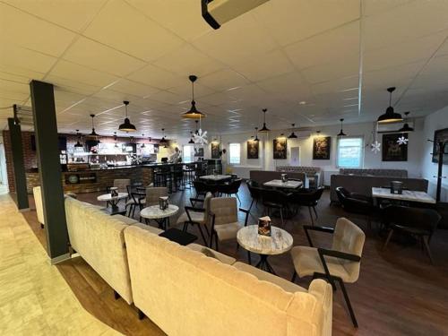 a restaurant with a couch and tables and chairs at Birlik in Tengiz