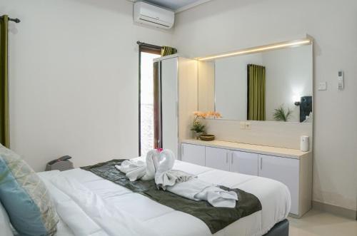 a bedroom with a bed with a large mirror at Bali Village Villa in Perean