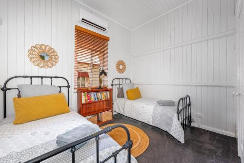 a bedroom with two beds and a window at Ambiente Cottage - Pet and Family Friendly in Toowoomba