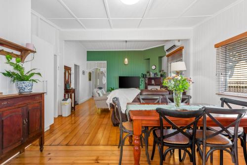 a living room with a table and a bedroom at Ambiente Cottage - Pet and Family Friendly in Toowoomba