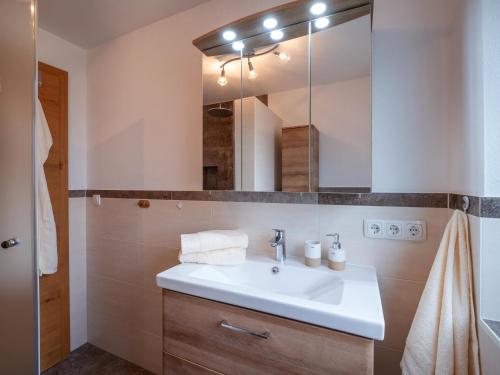 ein Bad mit einem Waschbecken und einem Spiegel in der Unterkunft Ferienwohnung Emmerenzia in Söll