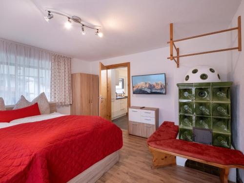 ein Schlafzimmer mit einem roten Bett und einer grünen Kommode in der Unterkunft Ferienwohnung Emmerenzia in Söll
