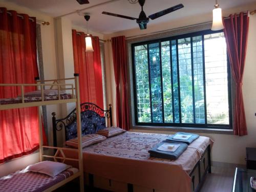 um quarto com 2 beliches e uma janela em Govindaashram em Bhogwe
