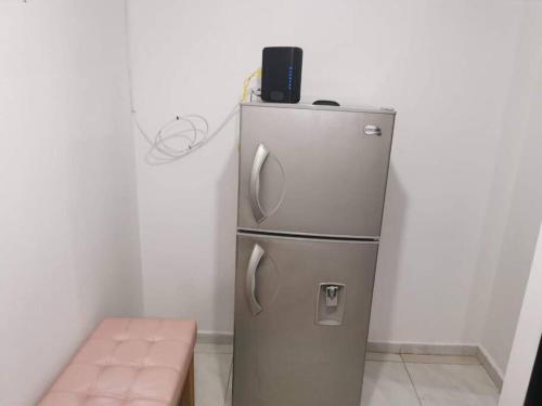een kleine koelkast met een telefoon erop bij Aparta estudio Puerta del Norte Niquia in Bello