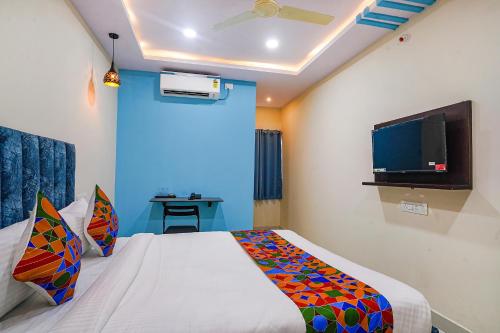 a bedroom with a bed and a flat screen tv at FabHotel Grand Broholic in Hyderabad