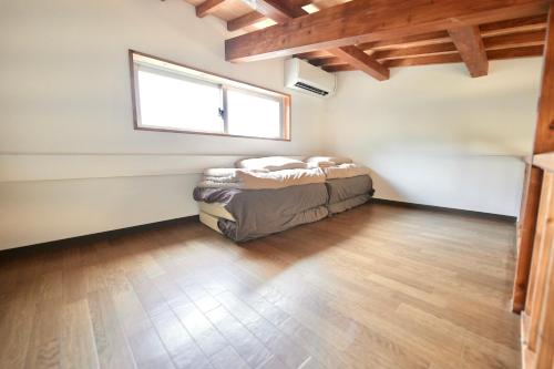um quarto com uma cama num quarto com uma janela em 宿屋padoma 