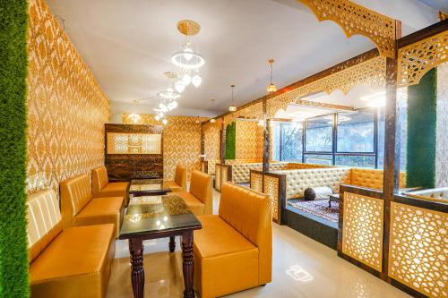 a restaurant with orange chairs and a table in a room at FabHotel Grand Broholic - Nr Hitech City in Hyderabad