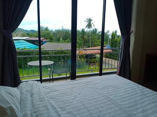 a bedroom with a bed and a view of a pool at Sj House Hotel Aonang in Ban Khlong Haeng