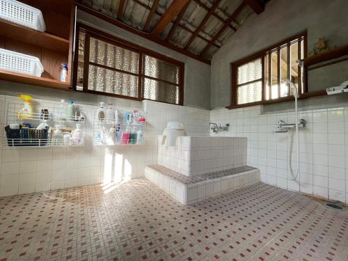 a bathroom with a shower and a sink in a room at 海人の宿 口福丸 KoufukuMaru in Yabiku