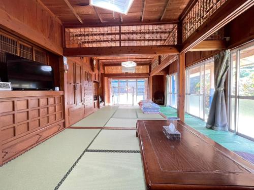 una grande camera con tavolo e tv di 海人の宿 口福丸 KoufukuMaru a Yabiku