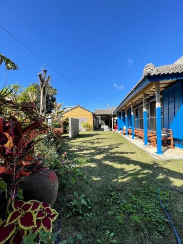 a blue building with a yard in front of it at 海人の宿 口福丸 KoufukuMaru in Yabiku