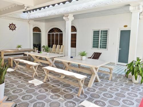 a patio with tables and chairs on a white house at Amy Motel Xuyên Mộc in Xuyên Mộc