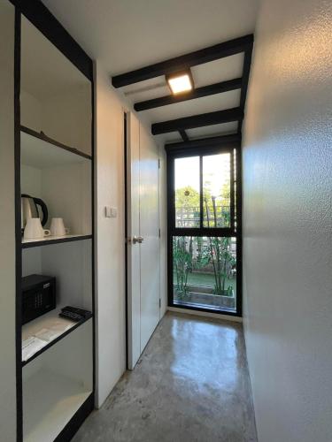 an empty room with a door and a window at Book a Bed Poshtel - SHA Plus in Phuket Town