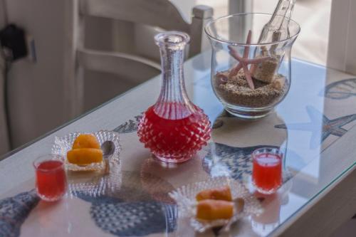 a glass table with a vase and a bowl of fruit at Sofi pension in Naxos Chora