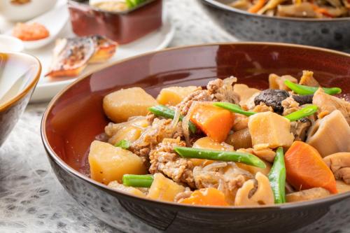 a bowl of food with meat and vegetables on a table at Hotel JAL City Fukuoka Tenjin in Fukuoka