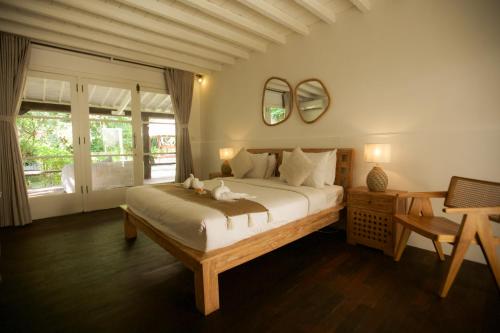 sypialnia z łóżkiem, stołem i lustrem w obiekcie Villa Tabatha by Optimum Bali Villas w mieście Seminyak