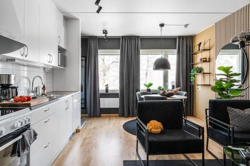 a kitchen with white cabinets and a table and chairs at Elite Business Suite in Nyköping