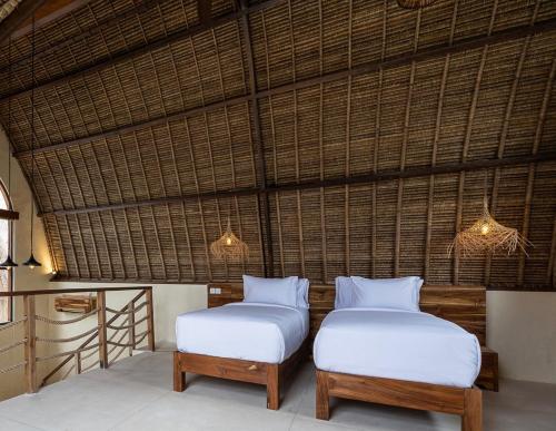 two beds and a stool in a room at Lulu's Villas in Uluwatu