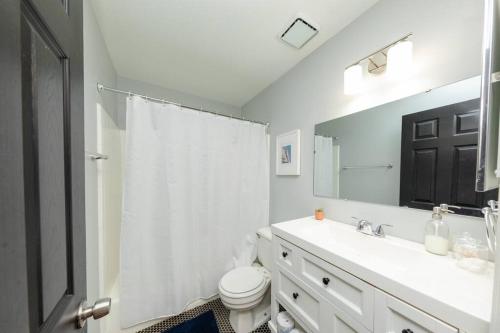 ein Badezimmer mit einem Waschbecken, einem WC und einem Spiegel in der Unterkunft Minutes to Broadway Large 2Br/2Ba with FREE private parking in Nashville