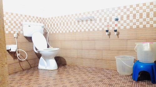 a bathroom with a toilet in a tiled wall at Sahyadri Homestay wayanad in Kalpetta
