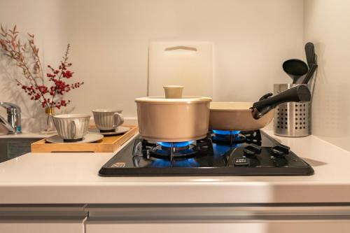 a pot sitting on top of a stove in a kitchen at 谷町君ホテル　難波80 in Osaka
