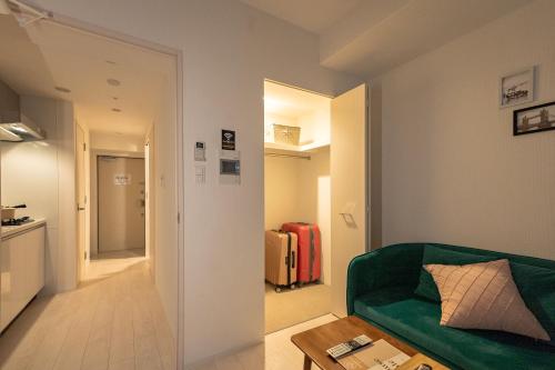 a living room with a green couch and a table at 谷町君ホテル　難波80 in Osaka