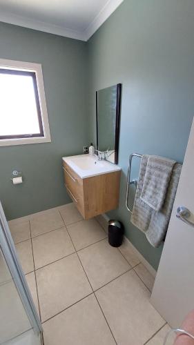 a bathroom with a sink and a mirror at Private guest room - no kitchen in Wanaka