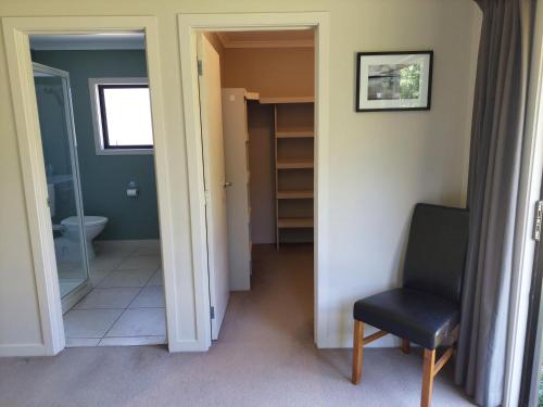 a hallway with a toilet and a chair in a room at Private guest room - no kitchen in Wanaka