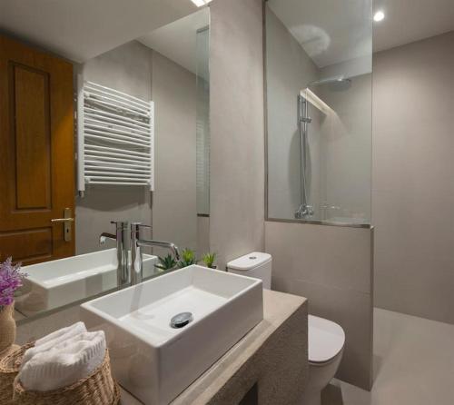 La salle de bains blanche est pourvue d'un lavabo et de toilettes. dans l'établissement Traditional chalet in Livadi, à Kalívia