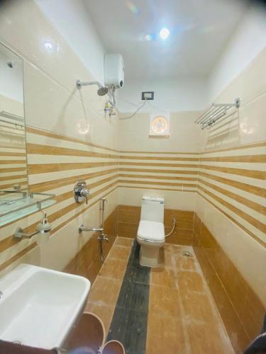 a bathroom with a white toilet and a sink at The Ginger Inn in Bhubaneshwar
